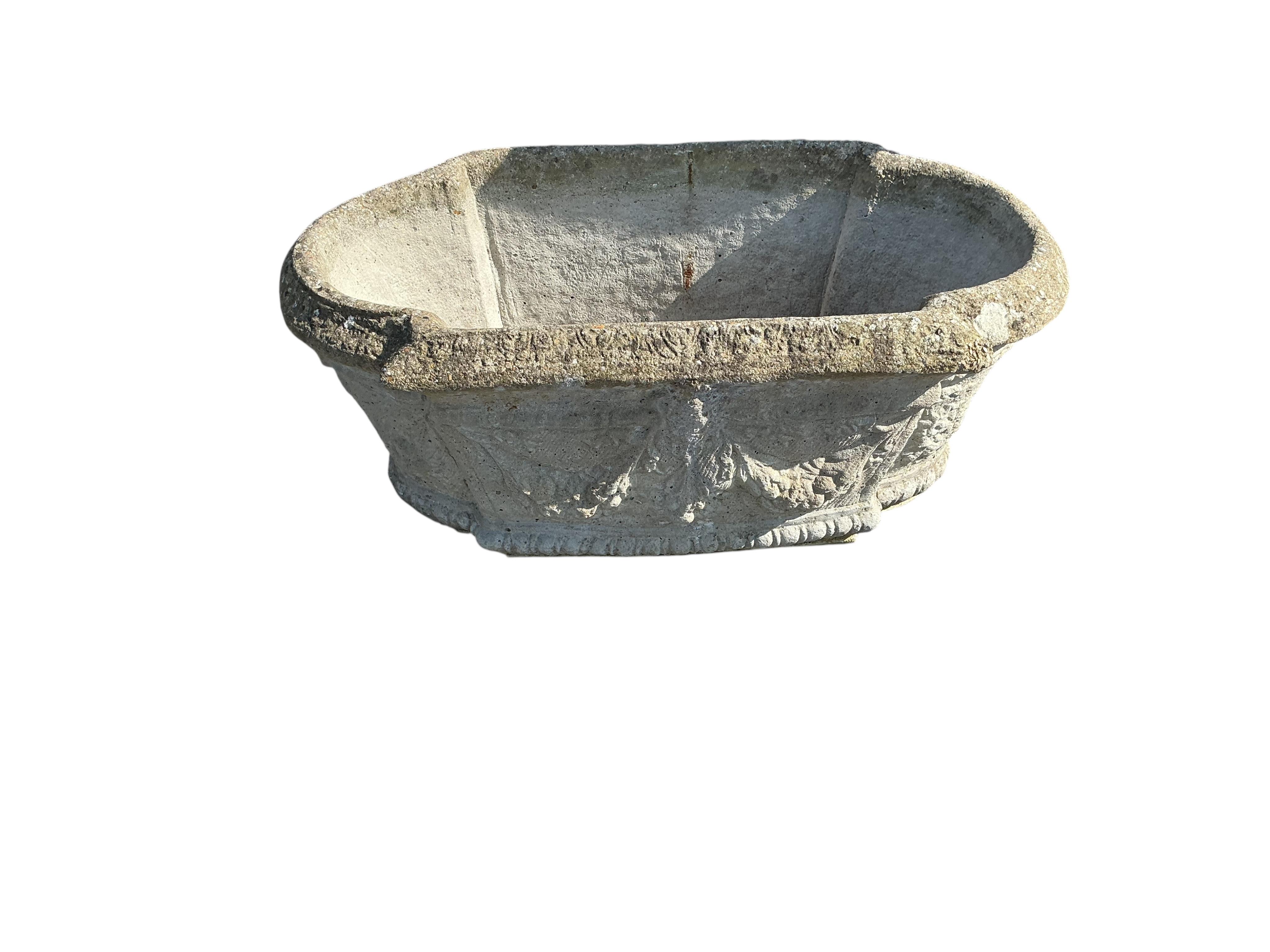 An oval reconstituted stone garden planter, width 80cm, height 30cm together with a circular stone planter